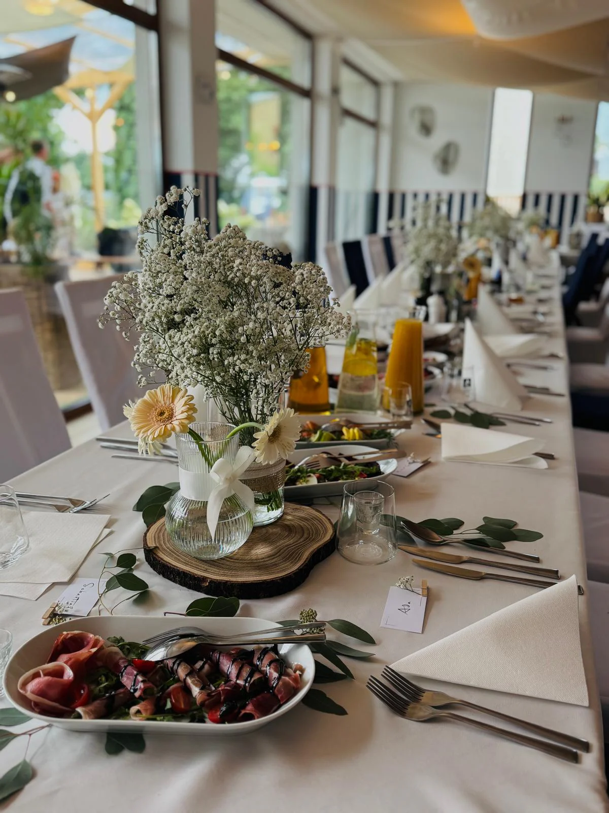 A table set for a celebration in the restaurant, with flowers and starters