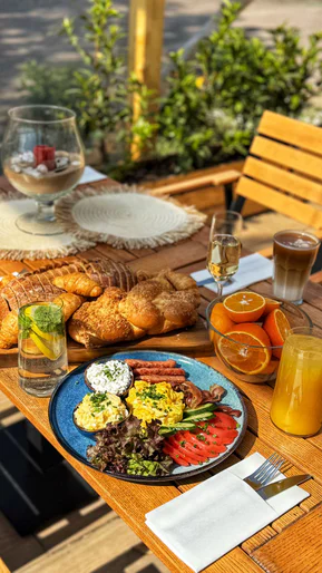 Breakfast on the terrace: scrambled eggs, tomatoes, bread, orange juice and coffee