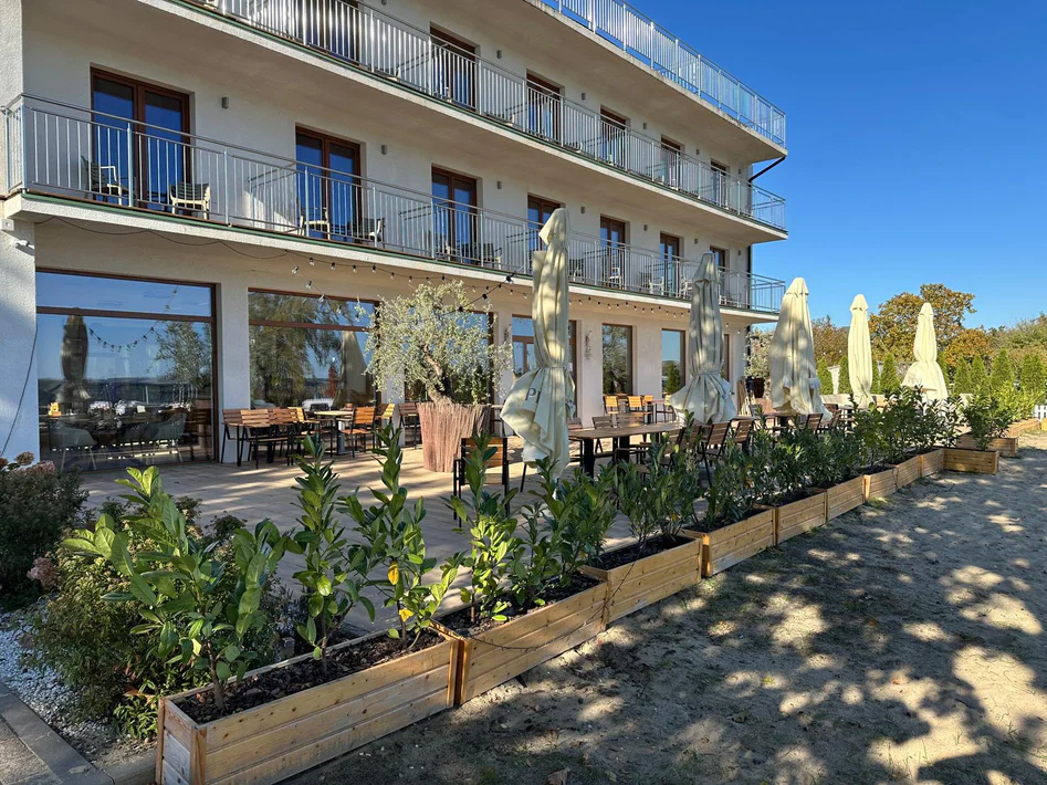 Hotel Relax Place od strony tarasu restauracji, z parasolami i donicami z zielenią