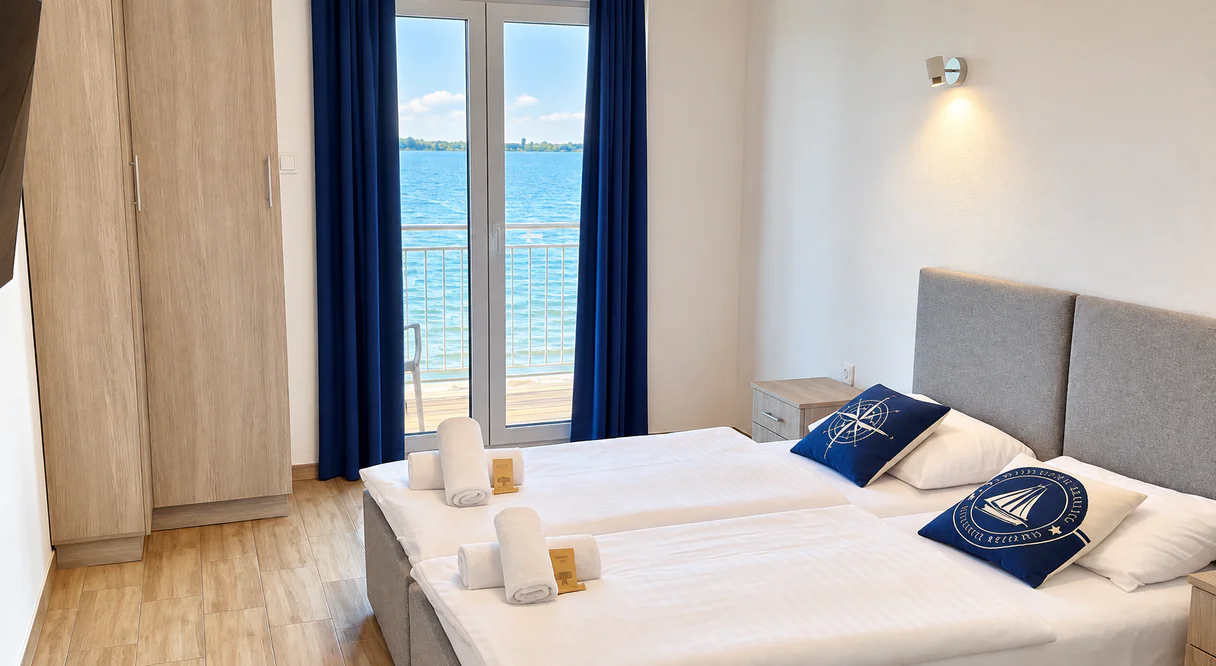 Room with a double bed and balcony doors looking out over the lake